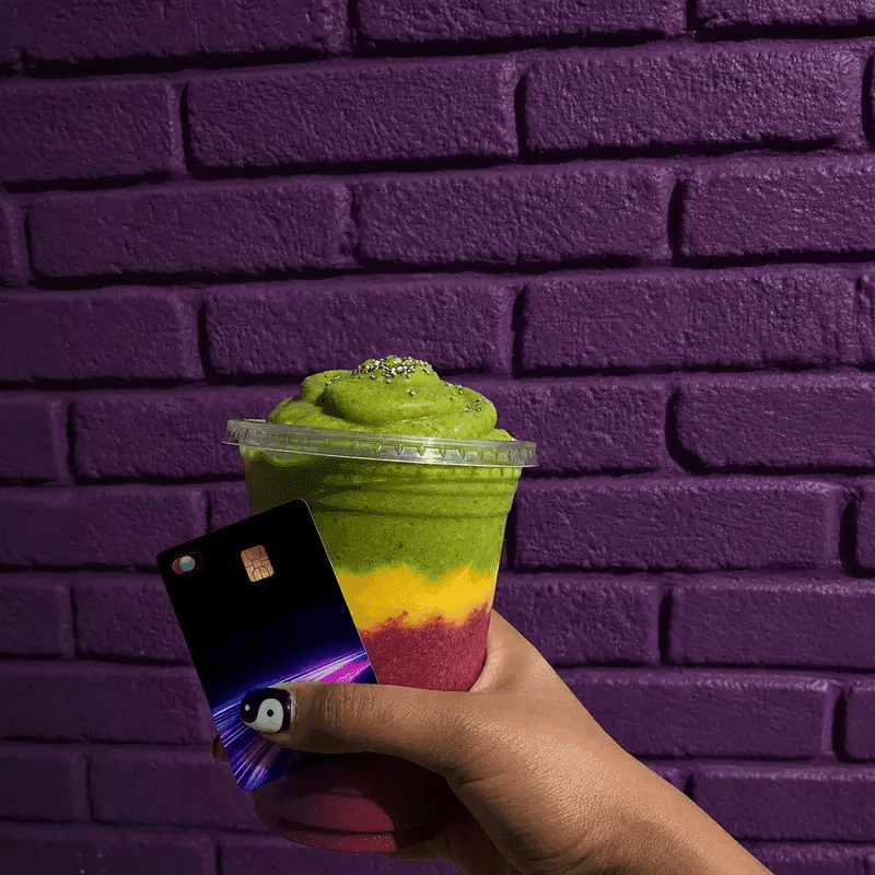 A layered matcha drink held beside a Bl!nk card